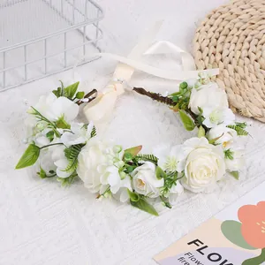 Détail de roses en soie ivoire et feuilles vertes tissées sur un bandeau de couronne