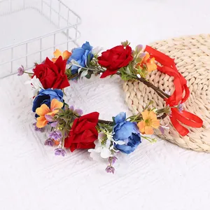 Detailansicht des roten Rosen-Blumenkranzes mit grünen Blättern und Seidenbändern