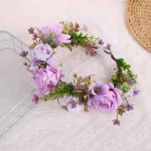 Detail der lila Stoffrosen und grünen Blätter am Boho-Haarband mit weißem Seidenband