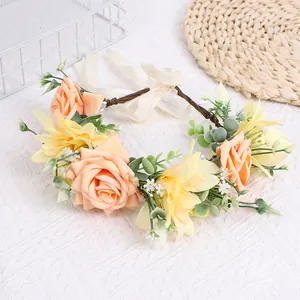 Detail of bohemian floral crown with pink roses, yellow lilies and ivory ribbons