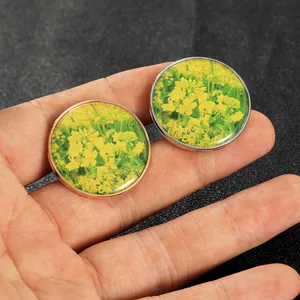 Close-up of handmade round glass charms featuring yellow rapeseed flower patterns