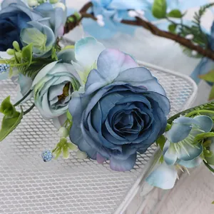 Vue détaillée de roses artificielles bleues et de baies sur une couronne de fleurs romantique
