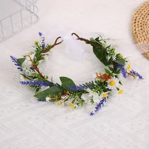 Detail von Blumenkrone mit weißen Gänseblümchen, Lavendel und weißen Bändern auf Textilfläche