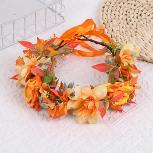 Détail d'une couronne florale bohème avec fleurs orange et ruban en satin éclatant