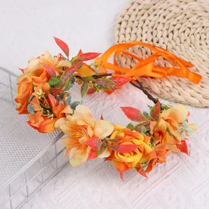 Détail de la couronne de mariée avec roses oranges et ruban satiné sur un tapis