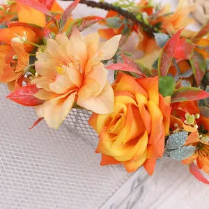 Gros plan détaillé d'une couronne de mariée faite main avec roses orange et feuilles vertes