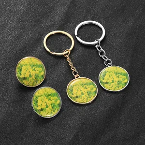 Detailed macro view of yellow rapeseed flower glass pendants in gold and silver settings
