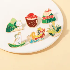 Detalle de pines esmaltados del Festival del Bote del Dragón con pandas y zongzi en bandeja