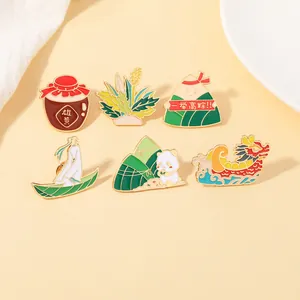 Detalle de pines de esmalte con panda comiendo zongzi y motivos de la fiesta del dragón