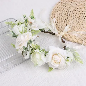 Détail d'un serre-tête floral fait main avec roses blanches et rubans en satin