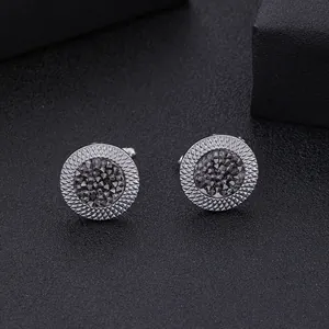 Gros plan de boutons de manchette argentés avec cristal gris et bords ciselés