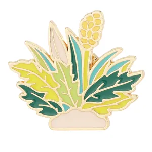 Broche botánico de esmalte con hojas verdes y flores amarillas sobre fondo blanco