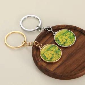 Close-up of gold and silver round pendants with yellow flower patterns on wood