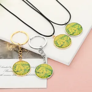 Close-up of assorted resin rape flower pendants including gold and silver necklaces and keychains