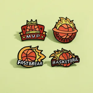 Dettaglio di quattro spille da basket in smalto con scritte MVP e design di fiamme