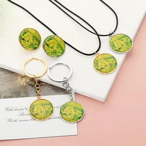 Macro detail of yellow rapeseed flower pendant necklace and vintage keychain set