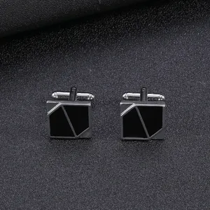 Detailed view of silver-tone geometric cufflinks with black enamel on leather