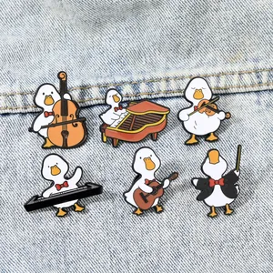 Set of six cute cartoon enamel duck brooches featuring musical instruments on denim fabric
