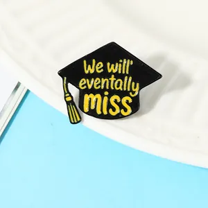 Close-up of black and yellow graduation cap enamel pin with commemorative text engraving