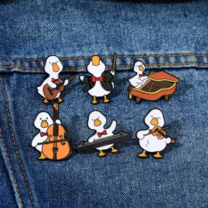 Detail of six cartoon duck enamel pins with musical instruments on denim fabric