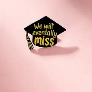 Detailed view of enamel graduation cap brooch with We will eventually miss inscription