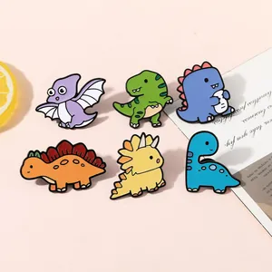 Set of six colorful enamel dinosaur pins featuring various species on a pink background