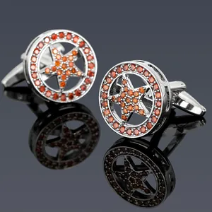Macro detail of silver-tone cufflinks featuring amber star pattern and crystals