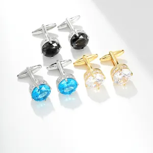 Macro view of round cufflinks with navy blue, black, and white zircon crystals