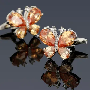Makroaufnahme silberner Schmetterlings-Manschettenknöpfe mit orangen Zirkonia-Steinen