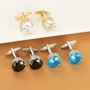 Detail of round gold cufflinks featuring crown settings with zircon and micro-pave accents