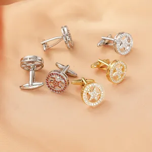 Exquisite gold and silver star cufflinks with inlaid red stones on orange silk fabric