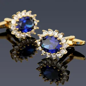 Macro shot of men's gold cufflinks with dark blue center stone and white zircon halo