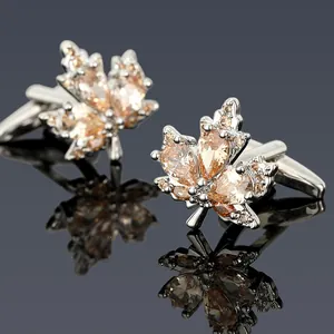 Gros plan de boutons de manchette en érable avec zircons champagne sur fond réfléchissant
