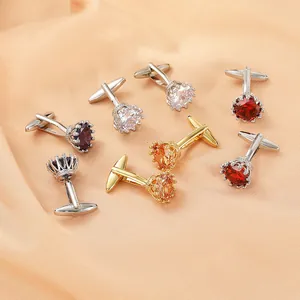 Elegantes gemelos de cristal con forma de corona en plata y oro sobre seda naranja