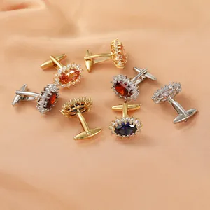 Macro detail of luxury halo-style cufflinks with oval crystals on silk fabric