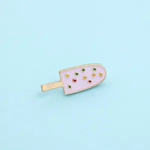 Detailed view of a pink enamel ice cream brooch with colorful sugar sprinkles and gold trim