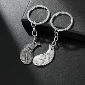 Detail view of silver dragon embossed interlocking puzzle keychain set for couples