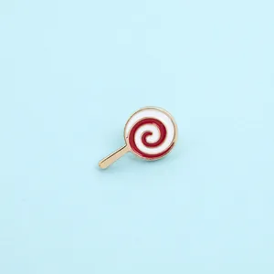 Macro detail of enamel lollipop brooch with red and white spiral design and gold finish