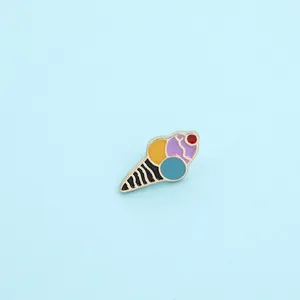 Macro detail of colorful ice cream enamel pin with vibrant yellow and blue scoops