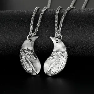 Detailed macro view of two interlocking silver dragon pendants with intricate scales