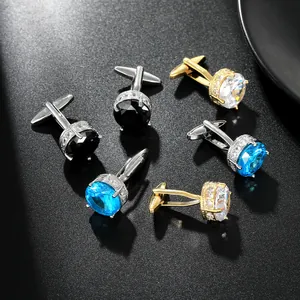 Macro view of luxury round cufflinks set with vibrant blue and champagne zircons