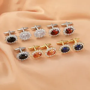 Detailed close-up of luxury oval crystal cufflinks in various colors on silk fabric