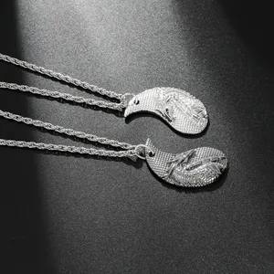 Detail of silver alloy dragon pendants for couples showing yin yang ring closure and chain