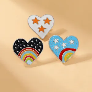 Lot de trois broches en émail en forme de cœur avec motifs arc-en-ciel et étoiles en alliage
