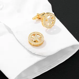 Men's gold circular cufflinks with star motif and diamonds on white shirt cuff