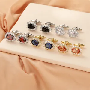 Close-up of vintage oval cufflinks with colorful crystals and sparkling diamond halos