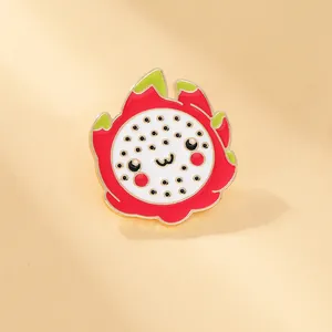 Close-up of a cute cartoon pitaya enamel pin with vivid colors and golden metal edges