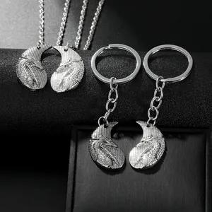 Detailed close-up of matching dragon motif necklaces and keychains in silver alloy
