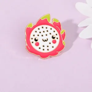 Close-up of cute cartoon dragon fruit enamel pin with pink color and gold plating