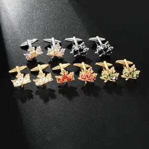 Détail macro de boutons de manchette en forme de feuille avec pierres colorées